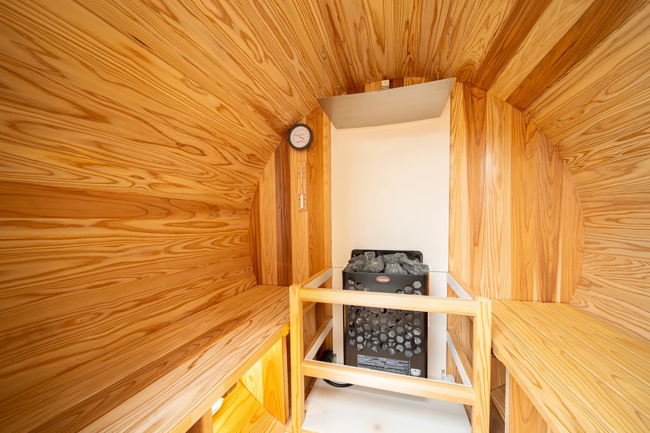 Inside the barrel sauna, surrounded by curved timber walls